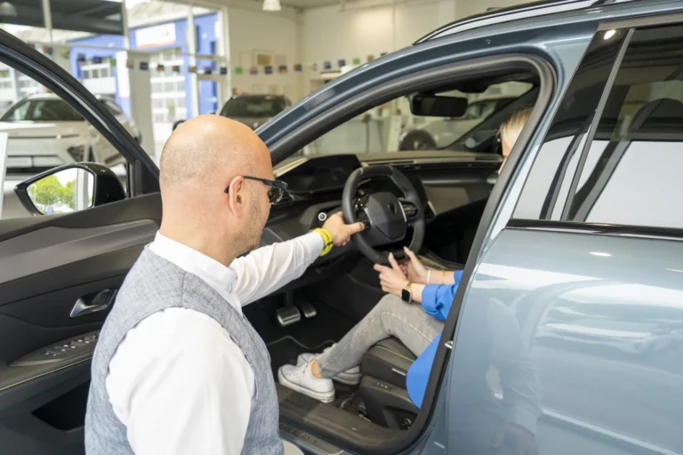 Berater zeigt einer Kundin den Innenraum eines Hyundai